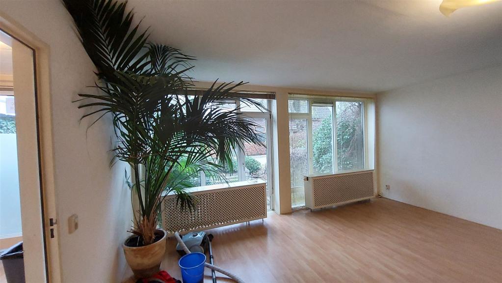 De woonkamer, met grote ramen en vrij uitzicht